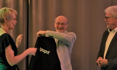 Peter Dekowski erhält vom Vors. Peter Ludwig und der 2. Vors. Monika Middelmann einen Poloshirt mit der Aufschrift „Turnpapst“  